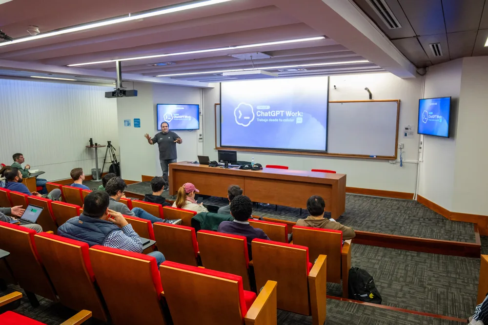 A speaker presenting a ChatGPT workshop to attendees in a lecture room